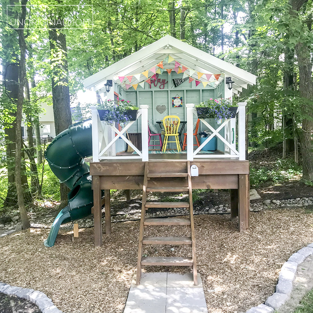 DIY Backyard Playhouse with Slide - this version of the Handmade Hideaway is a perfect raised playhouse for a sloped or wooded backyard!